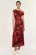 Woman wearing a red floral one-shoulder dress on a white background