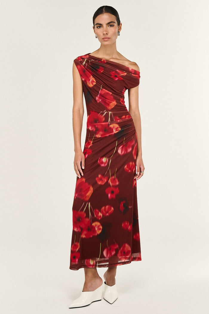 Woman wearing a red floral one-shoulder dress on a white background