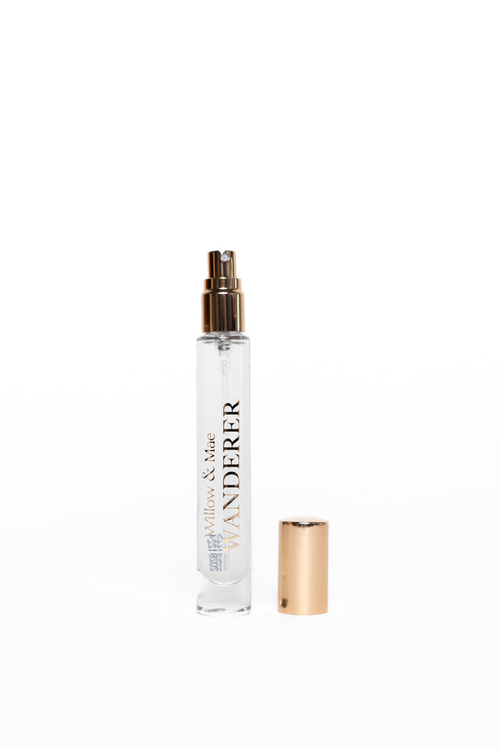 Small spray bottle with gold nozzle and cap on a white background