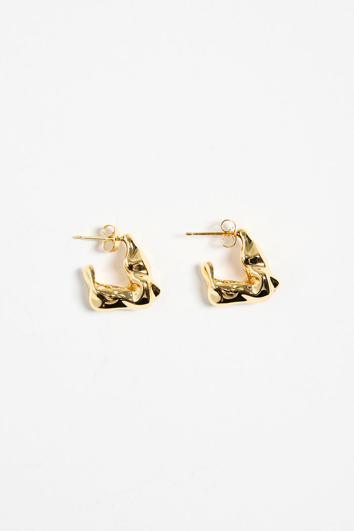 gold-plated brass huggie earrings with a wavy, organic design, photographed flat against a white background.