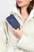 Person holding a blue wallet with a white coat