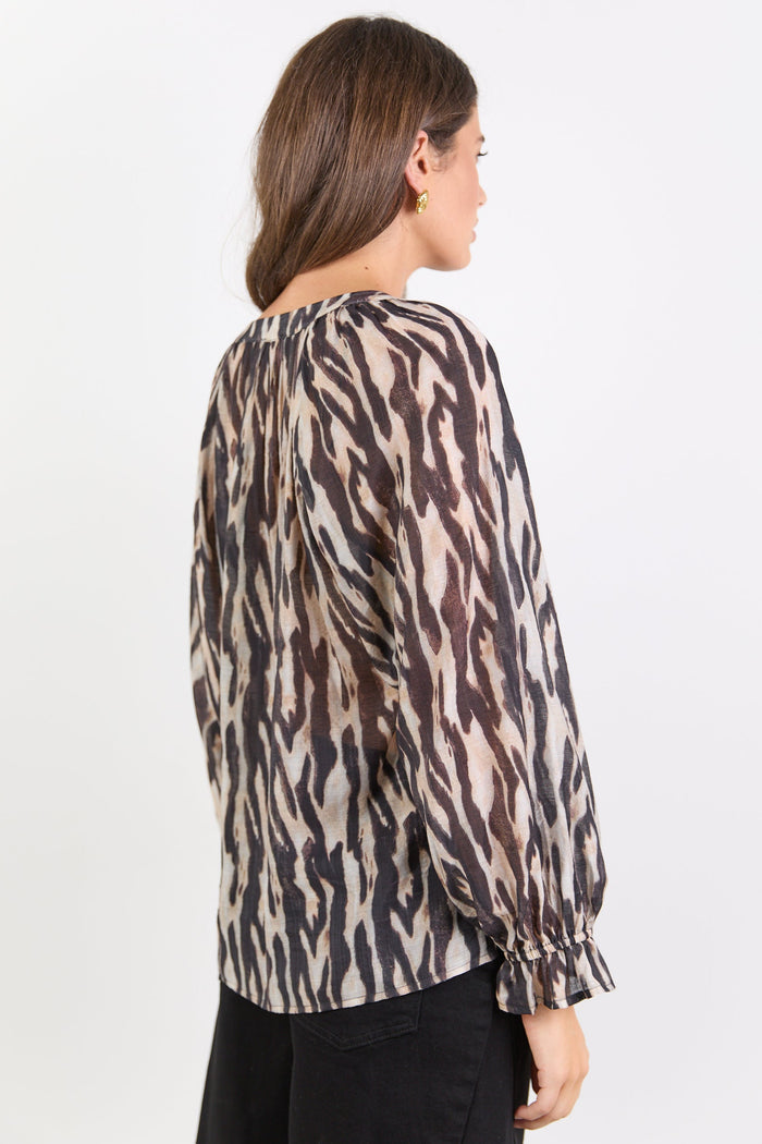 Woman wearing a leopard print blouse against a white background