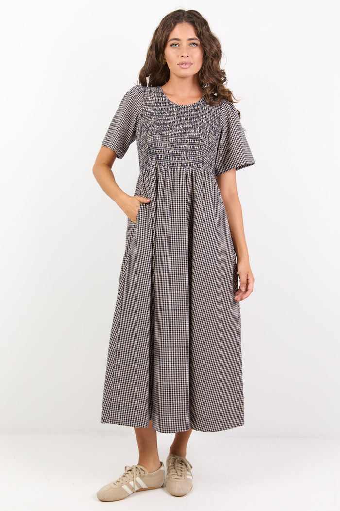 Woman wearing a gray checkered dress on a white background