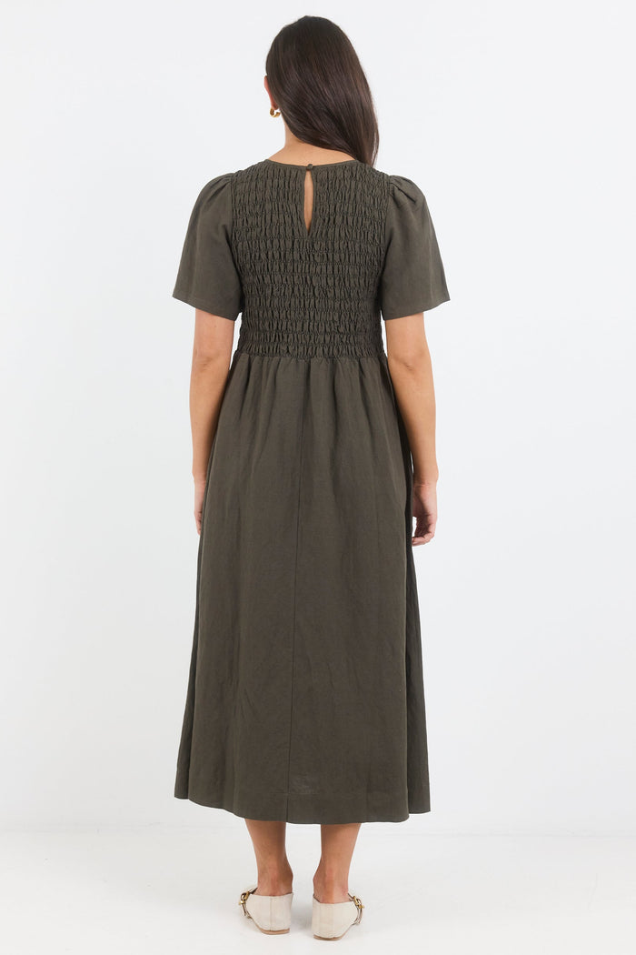 Woman wearing a green dress from behind on a white background