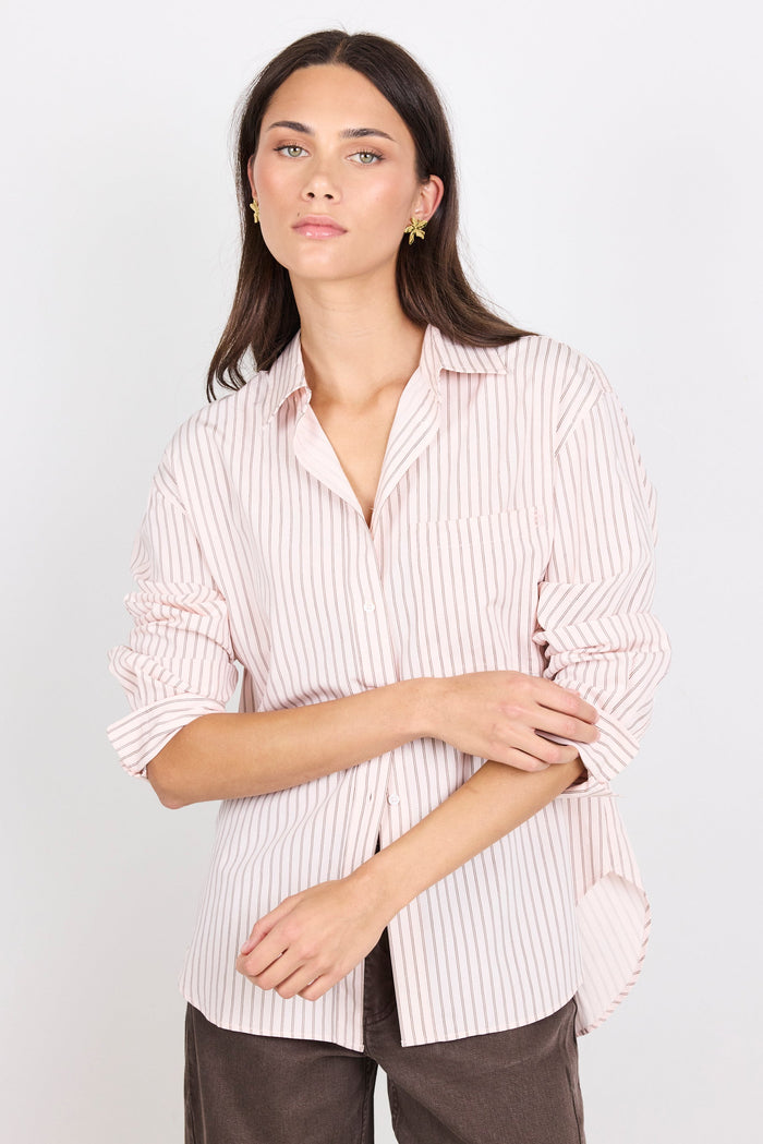 Woman wearing a striped shirt with a plain background