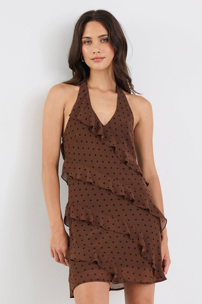 Woman wearing a brown polka dot dress on a white background
