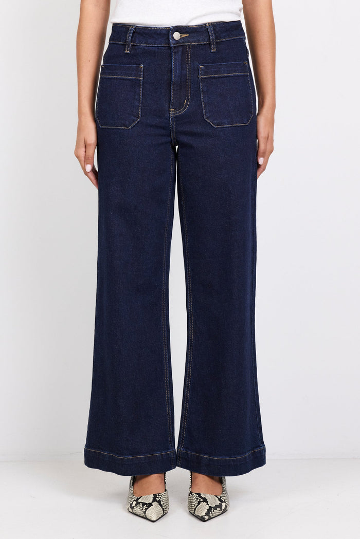 Person wearing dark blue jeans on a white background