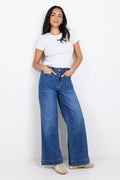 Woman wearing a white t-shirt and blue jeans on a white background