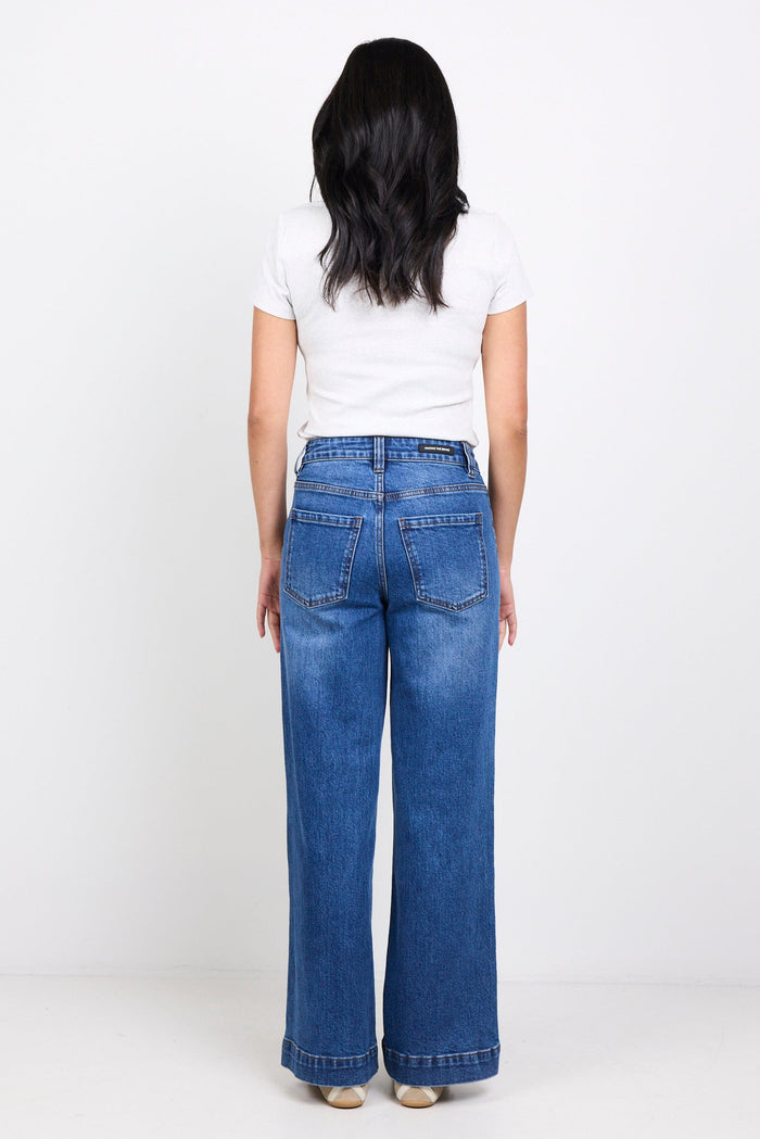 Person wearing blue jeans and a white shirt on a white background