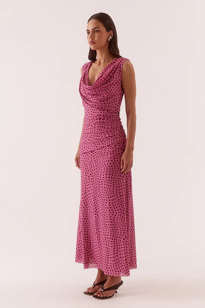 Woman wearing a pink patterned dress on a white background